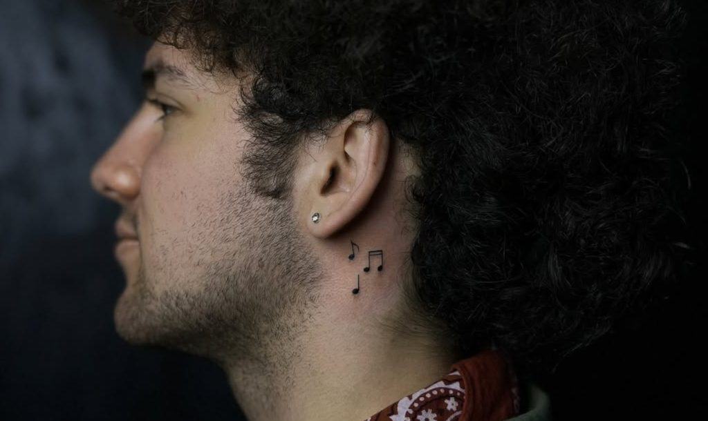 тату на шиї у вигляді музичних нот, мінімалістичний стиль, чорне чорнило